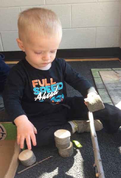 boy stacking round wood pieces
